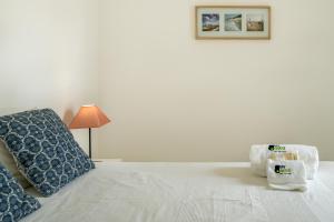 um quarto com uma cama com uma almofada e um candeeiro em BmyGuest - Santa Luzia Sunset Apartment em Tavira