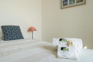 um quarto branco com uma cama e uma cadeira em BmyGuest - Santa Luzia Sunset Apartment em Tavira