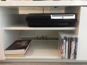 a book shelf with a dvd player and books at Apartment Caleta de Fuste in Caleta De Fuste