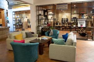 a living room with couches and a table and chairs at Chateau D'eau Hotel in Fārayyā