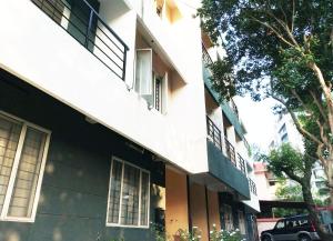 a building with windows and a car parked next to it at Honey Bee Serviced Apartments Trivandrum in Trivandrum