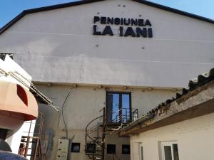 a white building with a sign on the side of it at Pensiunea La Iani in Constanţa