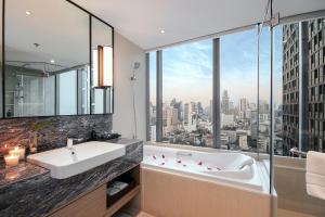 baño con bañera y ventana grande en Sivatel Bangkok Hotel, en Bangkok