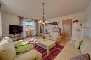 a living room with white furniture and a tv at Ferienwohnung IV Madek in Mauth