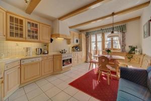 a kitchen with wooden cabinets and a table and chairs at Ferienwohnung IV Madek in Mauth