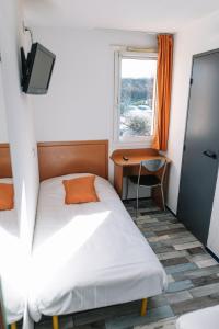 1 dormitorio con cama, escritorio y ventana en Welcomotel Limoges, en Limoges
