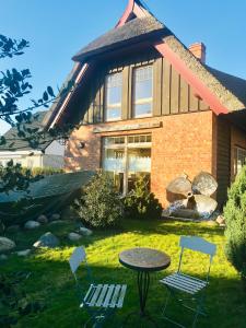 a house with two chairs and a table in the yard at "Bootsschuppen" by Ferienhaus Strandgut in Born