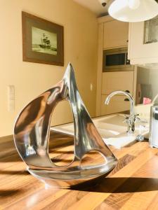 a silver shoe sculpture sitting on top of a kitchen counter at "Bootsschuppen" by Ferienhaus Strandgut in Born