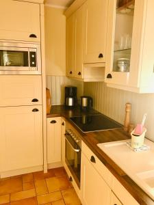 a kitchen with white cabinets and a stove top oven at "Bootsschuppen" by Ferienhaus Strandgut in Born +19 photos