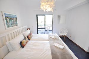 מיטה או מיטות בחדר ב-E&M Beach House Aldeamento do Levante III