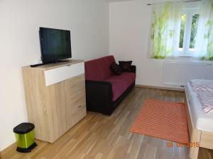 a living room with a couch and a flat screen tv at Ferienwohnungen Resch in Eckberg
