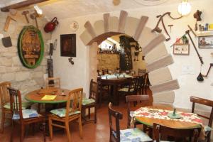 a restaurant with tables and chairs and a stone wall at Weinkeller Wölk in Naumburg
