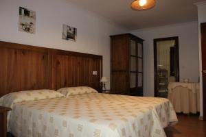 a bedroom with a large bed with a wooden headboard at Hostal Monte Rio in Peñamellera Alta