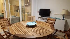 a wooden table with chairs and a television in a room at residenza " Verde Blu " in Capoliveri