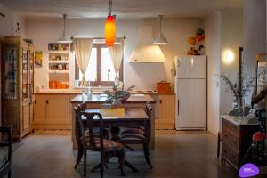 eine Küche mit einem Tisch und einem Kühlschrank in der Unterkunft Country House Spitaki in Velika