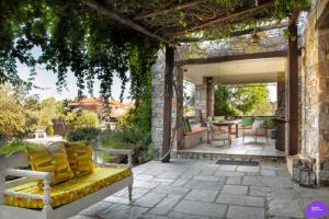 un patio con divano, tavolo e sedie. di Country House Spitaki a Velika