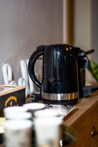 a black tea kettle sitting on a wooden table at La Lu cozy rooms in Pisa