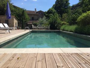 una piscina con terraza de madera y una piscina en Mas du Sommelier, en Le Beaucet