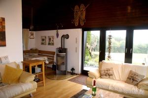 a living room with two white couches and a fireplace at Ferienhaus-4Seasons in Gönnersdorf