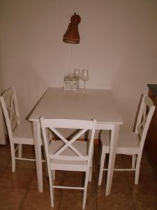 einen weißen Tisch und Stühle mit einer Lampe und Weingläsern in der Unterkunft Vabaduse Apartment in Kärdla