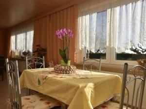 een tafel met een vaas met paarse bloemen erop bij Spacious Apartment in Brusow with Garden in Kröpelin