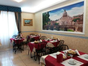 a restaurant with tables and a large picture of the vatican at Hotel Orlanda in Rome