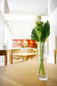 a vase with a white rose sitting on a table at CHERN Bangkok in Bangkok
