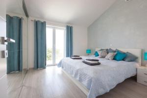 a bedroom with a large bed with blue curtains at Villa Retro fusion a luxury villa in Tucepi in Tučepi +21 photos