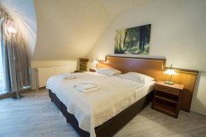 a bedroom with a large bed with two towels on it at Stadt Aparthaus in Waren