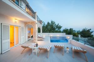 un patio con sillas y una piscina en Villa Retro fusion a luxury villa in Tucepi en Tučepi