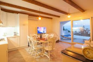a kitchen and dining room with a table and a clock at Villa Retro fusion a luxury villa in Tucepi in Tučepi