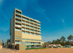 um edifício alto na praia ao lado de uma praia em Pledge Scape em Negombo