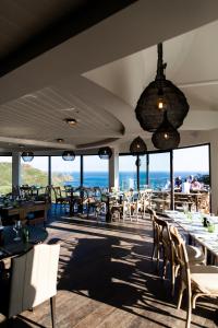 een restaurant met tafels en stoelen en uitzicht op de oceaan bij Gara Rock in Salcombe