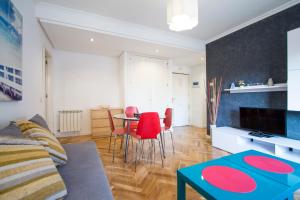 sala de estar con mesa y sillas rojas en Apartamento Green City Deco, en Madrid