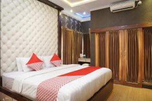 a bedroom with a large white bed with red pillows at Super OYO 444 Rafitha Homestay in Yogyakarta