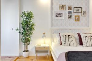 a bedroom with a white bed and a potted plant at January's 31 Studio by DA'HOME in Porto