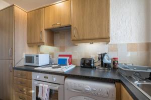 eine Küche mit einer Arbeitsplatte mit einer Mikrowelle und einem Geschirrspüler in der Unterkunft Brucefield Avenue in Dunfermline