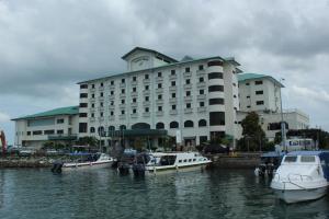 a large building with boats docked in the water at Seafest Hotel in Semporna