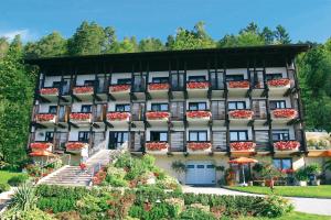 ein Apartmenthaus mit Blumen davor in der Unterkunft Hotel Garni Frühstückspension Neff in Velden am Wörthersee