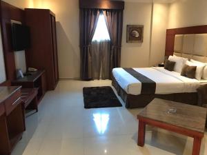 a hotel room with a large bed and a table at Nawara NASR - Economic in Riyadh