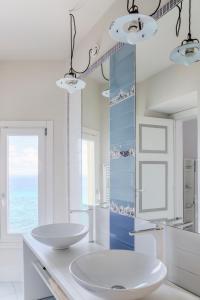 a white bathroom with two sinks and a mirror at Palazzo Mottola Tropea in Tropea