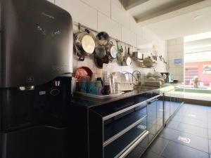 a kitchen with pots and pans hanging on the wall at Beds In Garden Hostel in Ipoh