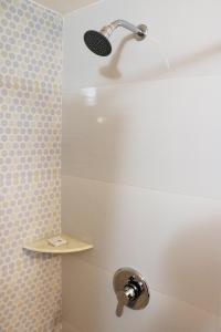 a shower with a shower head in a bathroom at The Three Oaks Boutique Hotel in Mussoorie