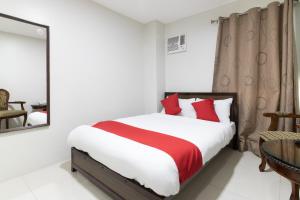 1 dormitorio con cama, mesa y espejo en OYO 152 Sangco Condotel, en Manila