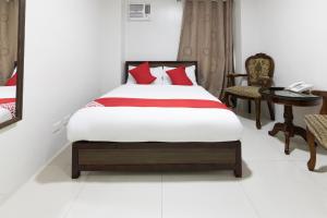 a bedroom with a bed and a telephone and a table at OYO 152 Sangco Condotel in Manila