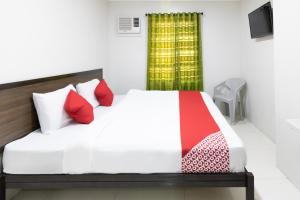 1 dormitorio con cama blanca y almohadas rojas en OYO 152 Sangco Condotel en Manila