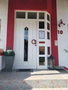 eine weiße Tür eines Gebäudes mit einer roten Wand in der Unterkunft Ferienwohnung Weiss in Rust
