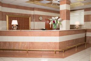 a waiting room with a vase of flowers on a wall at Luch Hotel in Moscow