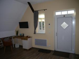 Zimmer mit einer Tür, einem Schreibtisch und einem Fenster in der Unterkunft Café im Hof in Streufdorf