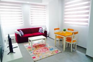 - un salon avec un canapé rouge et une table dans l'établissement Modern Suites, à Antalya